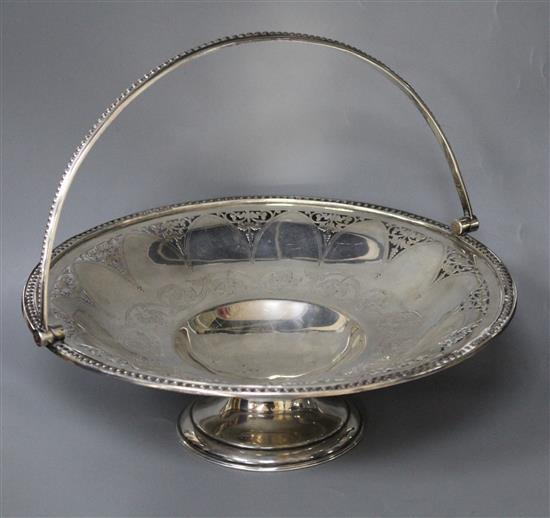 A Victorian engraved and pierced silver circular pedestal dish with swing handle, B.B, Sheffield, 1865,